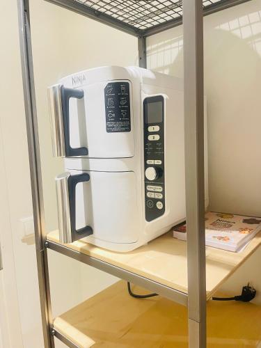 a white microwave sitting on top of a shelf at Family Apartment in Tallinn