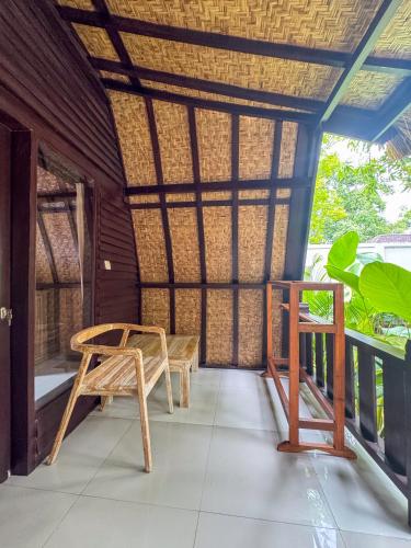 a room with a bench and a table on a porch at Villa Tahid in Gili Air