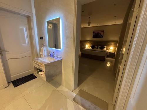 Un baño con lavabo y una cama en una habitación. en شقق زهرة السلام الفاخرة, en Medina