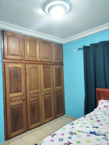 a bedroom with wooden cabinets and a bed at YB-TECHs in Mbala