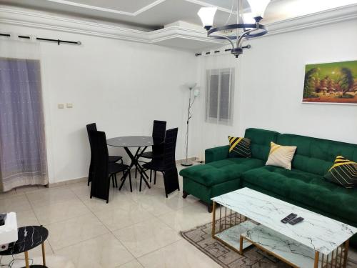 a living room with a green couch and a table at YB-TECHs in Mbala
