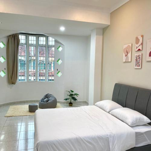 Un dormitorio con una cama grande y una ventana. en Cozyhaus Ipoh, en Ipoh
