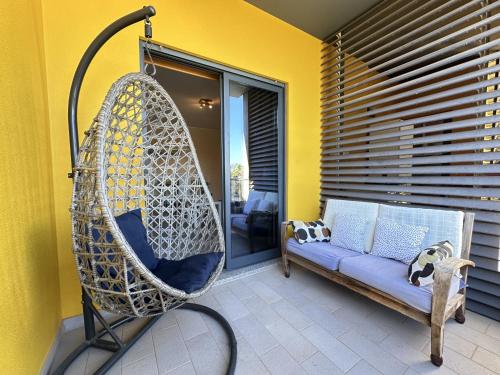 a porch with a swing and a couch on a patio at Quarteira Stylish 3 with Pool by Homing in Quarteira