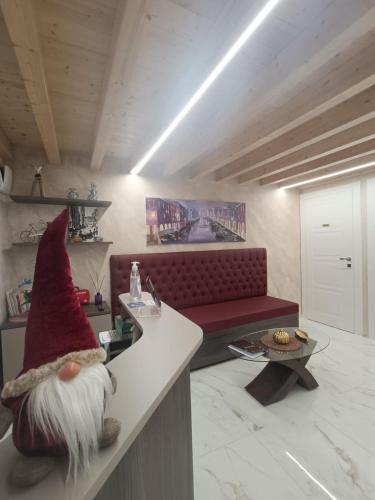 a living room with a red couch and a hat on a counter at Dal Doge - Guest House in Chioggia