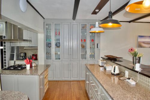 a kitchen with white cabinets and granite counter tops at Seabatical in Knysna