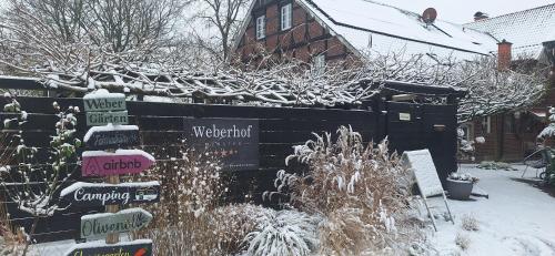 a garden covered in snow with signs on a fence at Weberhof - Münster 6 in Münster