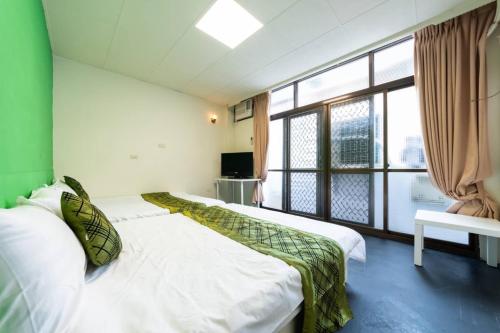 a bedroom with two beds and a large window at 日月潭水里東方海悅輕旅包棟 in Shuili