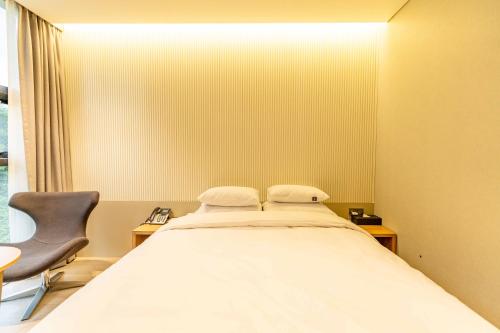 a hospital room with a bed and a chair at Lagobaum Hotel in Sejong