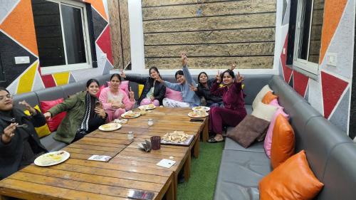 a group of women sitting around a table at Bedweiser Backpackers Hostel in Agra