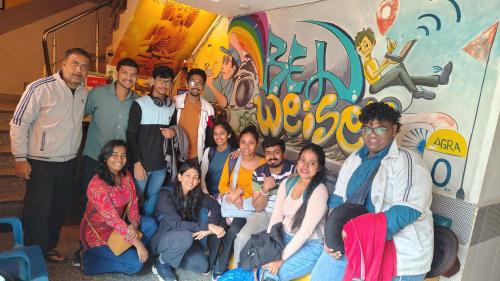 a group of people posing for a picture in front of a wall at Bedweiser Backpackers Hostel in Agra