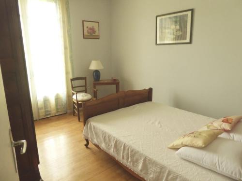 une chambre avec un lit, une chaise et une fenêtre dans l'établissement Monpazier Country House in Périgord, à Gaugeac