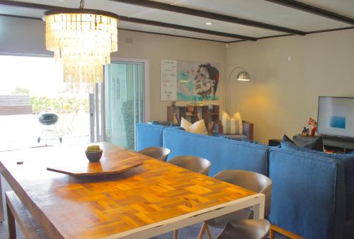 a dining room with a wooden table and chairs at Seabatical in Knysna