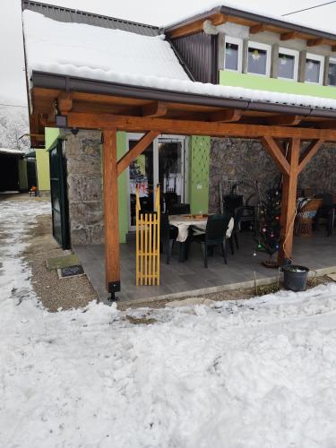 a house with a covered patio in the snow at Zeleni raj in Hreljin Ogulinski