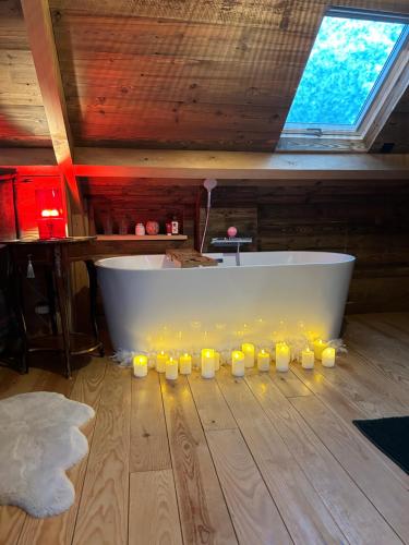 a bath tub with candles on the floor in a room at les chalets de Maryline in Accous