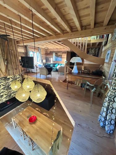 a living room with a table and some chandeliers at les chalets de Maryline in Accous