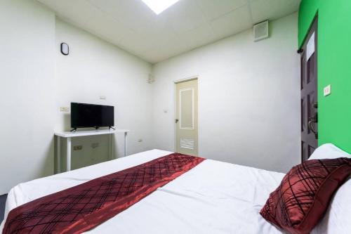 a bedroom with a bed and a flat screen tv at 日月潭水里東方海悅輕旅包棟 in Shuili