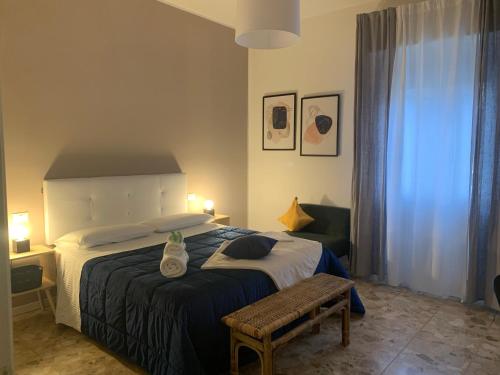 a bedroom with a bed with a bench and a window at b&b Calvino in Piacenza