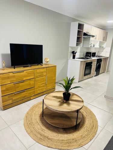a living room with a table and a tv at Homely Stay 3 in Kempton Park