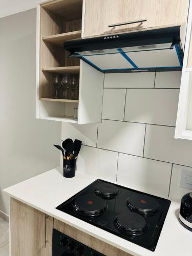a black stove top in a white kitchen at Homely Stay 3 in Kempton Park