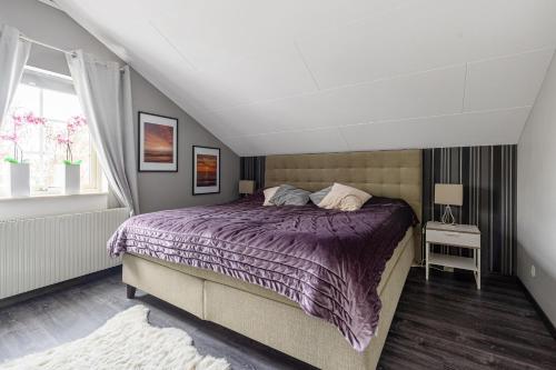 a bedroom with a purple bed and a window at Mysig villa Stockholm in Stockholm