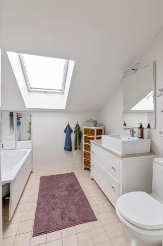 a bathroom with a sink toilet and a skylight at Mysig villa Stockholm in Stockholm