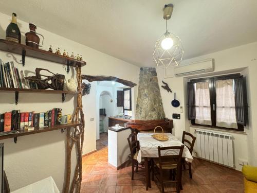 Un comedor con una mesa y una cocina. en Su Niu, en Ulassai