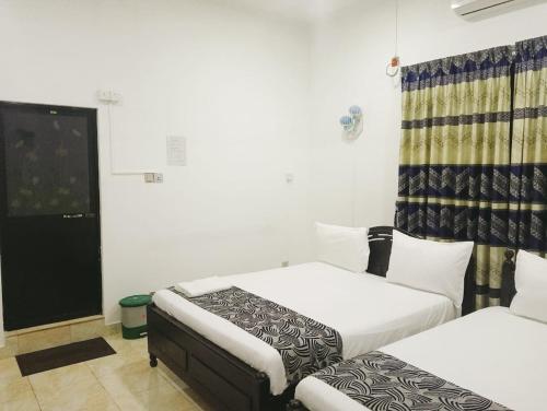 a room with two beds and a window at Treatooo Lake resort in Batticaloa