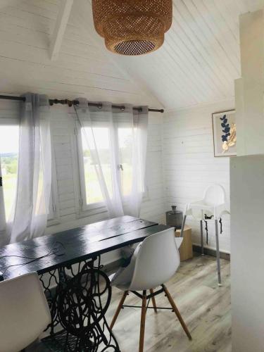 une salle à manger avec une table et des chaises blanches dans l'établissement La cabane scandinave, à Rimoux