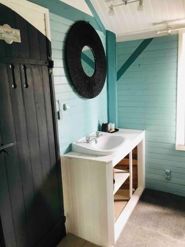 une salle de bain avec un lavabo blanc et un miroir dans l'établissement La cabane scandinave, à Rimoux