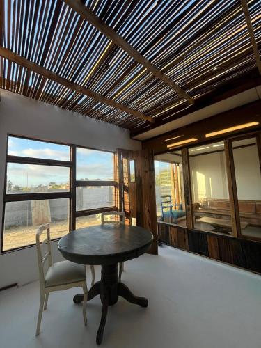 a table and chairs in a room with windows at Estudio modular independiente in Coquimbo