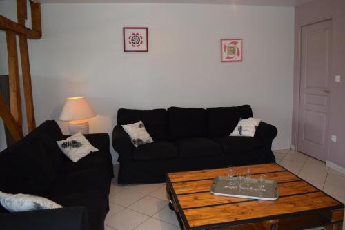a living room with a black couch and a coffee table at Ferme du lin : Rosalin in Gueschart