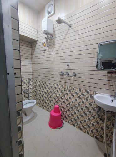 a bathroom with a toilet and a pink stool at A ShivAngan Heritage Home Stay Near Ghat in Varanasi