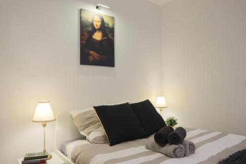 une chambre avec un lit avec un tableau sur le mur dans l'établissement Oeuvres françaises, à Mulhouse