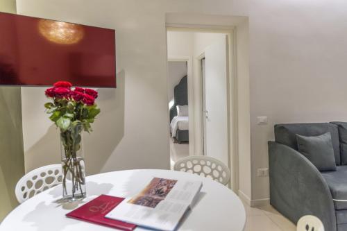 a vase of flowers on a table with a chair at Opera Relais De Charme - Aparthotel in Verona