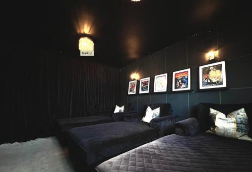 a dark room with couches and pictures on the wall at Southern Lane Beach House in Barton on Sea