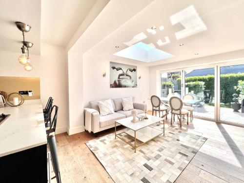 a living room with a couch and a table at Southern Lane Beach House in Barton on Sea