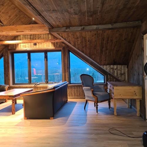a room with a desk and a chair in a room with windows at Småbruk in Fyresdal