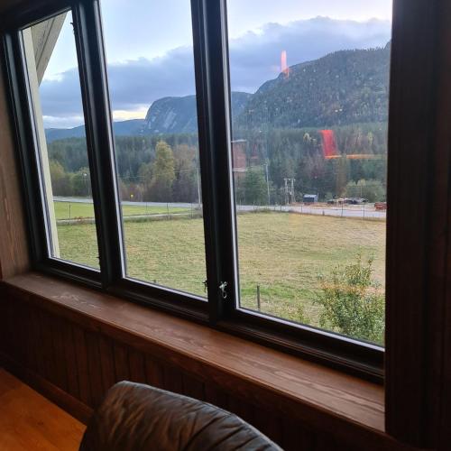 a window with a view of a field and mountains at Småbruk in Fyresdal