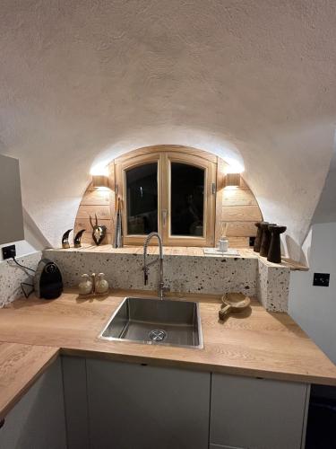 un comptoir de cuisine avec un évier et une fenêtre dans l'établissement Appartement neuf à 300m des pistes, à Saint-Chaffrey