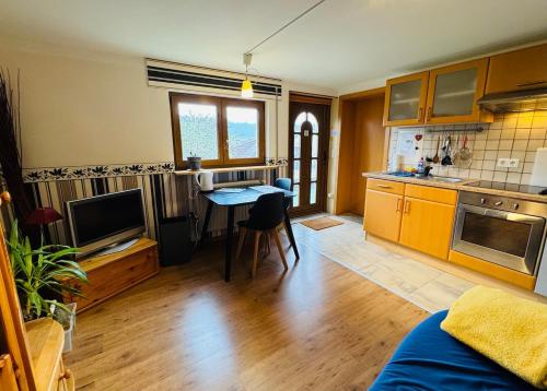 a kitchen with a table and a television in a room at Moselle Magic in Stadtbredimus