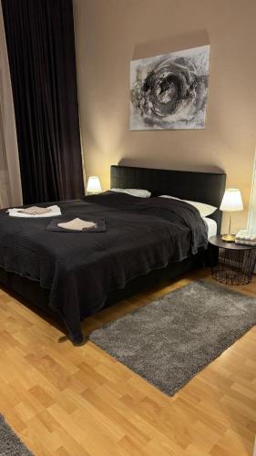 a bedroom with a black bed and a rug at Downtown Chalet in Braunschweig in Braunschweig