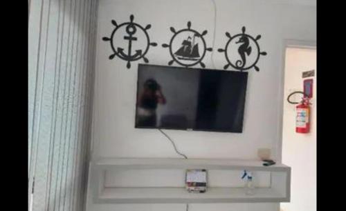 a person taking a picture of a tv on a wall at Apartamento pé na areia na praia de enseadas dos corais-Gaibu, em frente as piscinas naturais in Cabo de Santo Agostinho