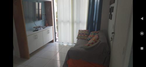 a room with a couch and a bathroom with a mirror at Apartamento pé na areia na praia de enseadas dos corais-Gaibu, em frente as piscinas naturais in Cabo de Santo Agostinho