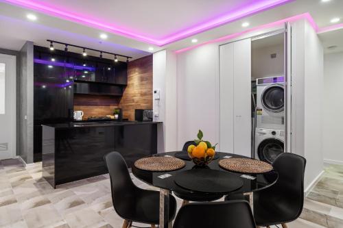 a kitchen with a black table and chairs and a washing machine at Central Luxury 3BR Apartment for up to 8 Guests in Melbourne