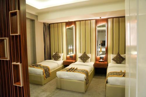 a room with four beds in a room at The Capital Heart Hotel in Baghdad