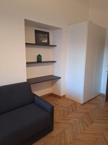 a living room with a black couch and shelves at Chic Brand New Apartment at Palazzo Giuliani in Verbania in Intra
