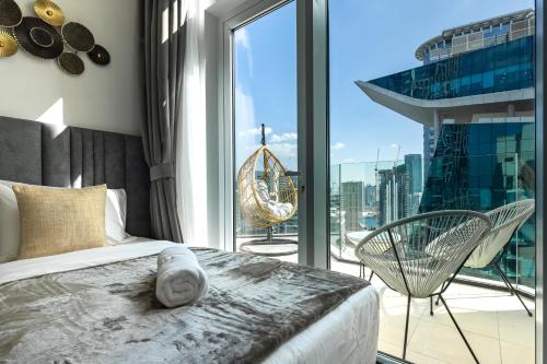a bedroom with a bed and a large window at Simply Comfort Vacation Homes Rental in Missoni Top Floor with Sea, Canal and Burj Khalifa Views in Dubai