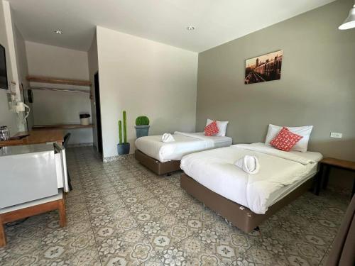 a hotel room with two beds and a sink at Warmwell Hostel in Ban Chuk Kum