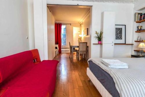 un salon avec un canapé rouge et une table dans l'établissement 02 grand studio near montorgueil, à Paris