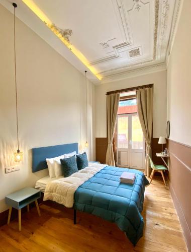 a bedroom with a bed with a blue blanket at Ambiente Hostel in Lisbon